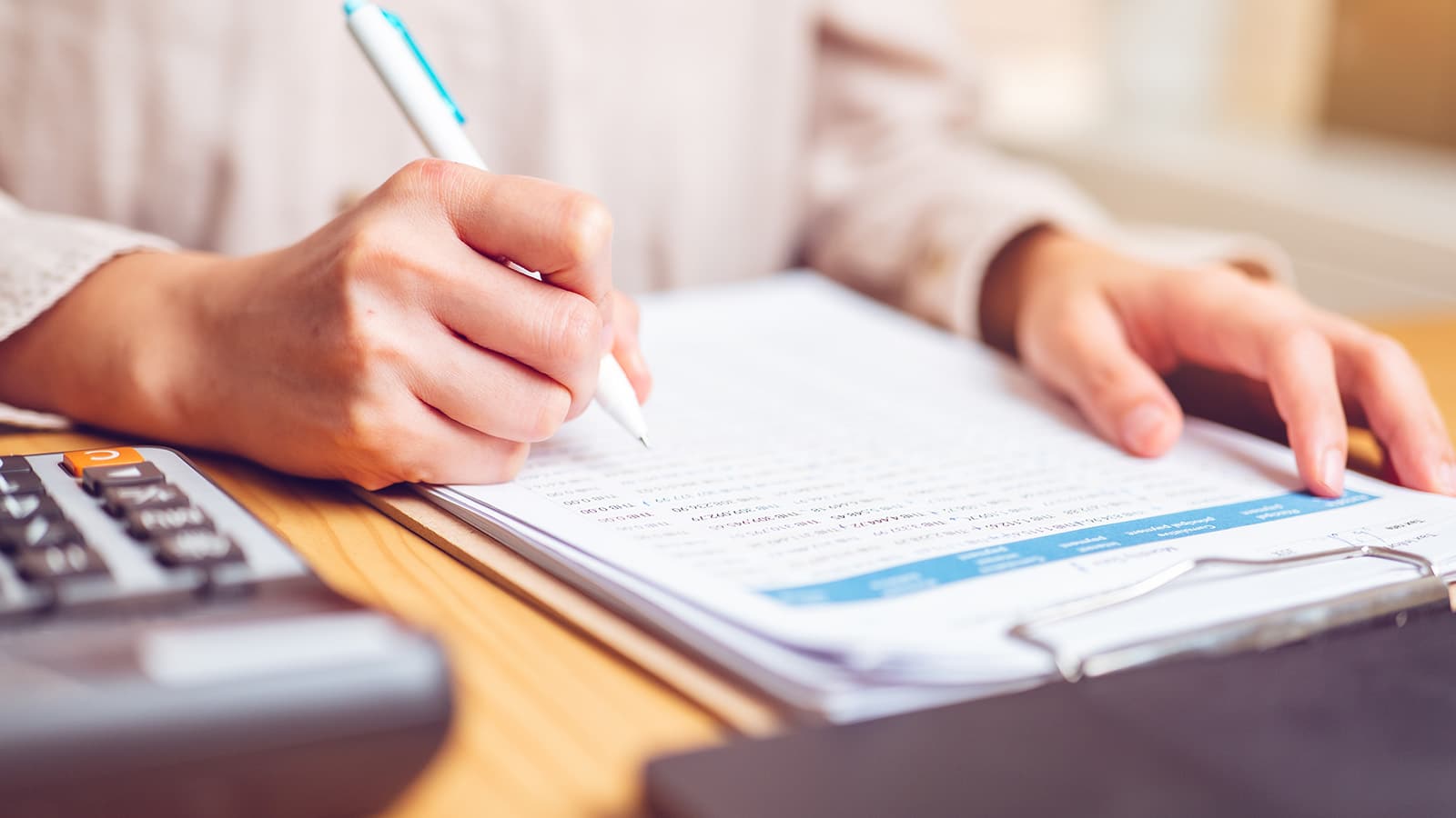 Appraiser completing a property appraisal report at a desk with a calculator - what is uspap - Ambrose