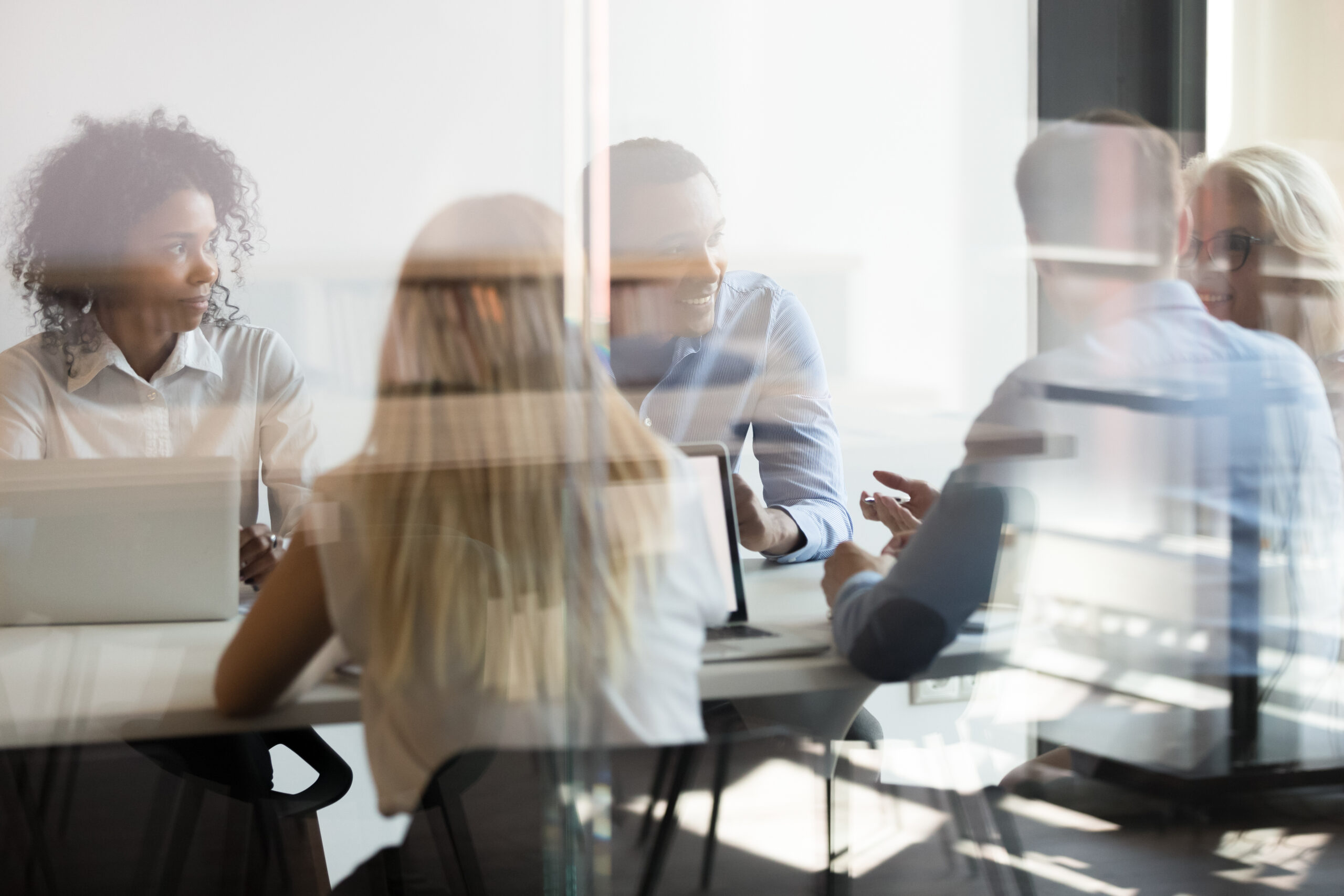 Multicultural Employees Talking At Team Meeting Sit At Conference Table